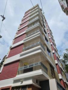 a tall red and white building with windows at Cozy Stay in New Flat, Dhaka, BD in Dhaka