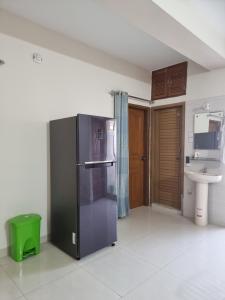 a kitchen with a black refrigerator and a sink at Cozy Stay in New Flat, Dhaka, BD in Dhaka