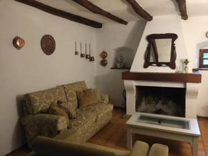 a living room with a couch and a fireplace at Casa El Collado in Alájar