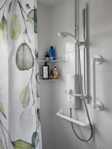 een douche in een badkamer met een douchegordijn bij Pontefract Home EV Charger in Pontefract