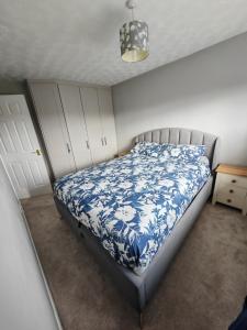 een slaapkamer met een bed met een blauw en wit dekbed bij Pontefract Home EV Charger in Pontefract
