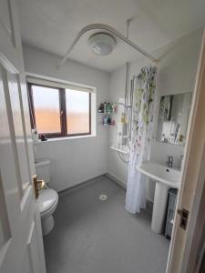een witte badkamer met een toilet en een wastafel bij Pontefract Home EV Charger in Pontefract