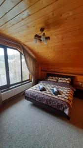 een slaapkamer met een bed in een houten hut bij Карпатський затишок in Oryavchyk