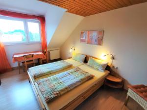 Schlafzimmer mit einem Bett, einem Tisch und einem Fenster in der Unterkunft BodenSEE Apartments Daisendorf nahe Meersburg in Daisendorf
