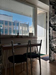 cocina con mesa, 2 sillas y ventana en Kuninkaankatu Apartment - Free Parking en Kuopio
