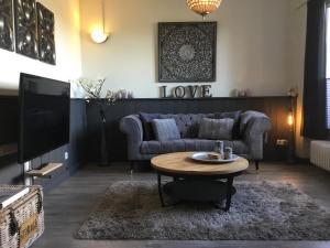 ein Wohnzimmer mit einem Sofa und einem Tisch in der Unterkunft Ferienwohnung Lands Huys in Dersum