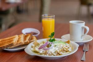 una mesa con un plato de comida y un vaso de zumo de naranja en La Joya Pachuca, en Pachuca de Soto