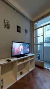 uma sala de estar com uma televisão de ecrã plano num armário branco em Tucuman y Carlos Pellegrini em Buenos Aires