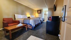 une chambre d'hôtel avec un lit et une chaise dans l'établissement Welcome Everett Inn, à Everett
