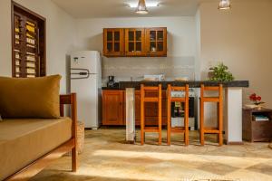 uma cozinha com um frigorífico e uma mesa com cadeiras em Apartamento Breezes em Jericoacoara