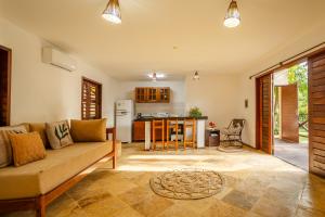uma sala de estar com um sofá e uma cozinha em Apartamento Breezes em Jericoacoara