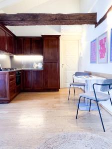 - une cuisine avec des placards en bois, une table et des chaises dans l'établissement ComeCasa Ampio Bilocale in Piazza San Secondo, à Asti