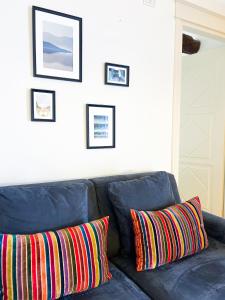 - un canapé bleu avec des oreillers colorés dans le salon dans l'établissement ComeCasa Ampio Bilocale in Piazza San Secondo, à Asti