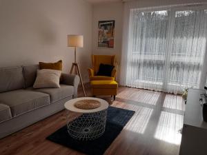 a living room with a couch and a table and a chair at Apartament Stay with Gdynia in Gdynia