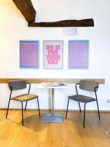 - deux chaises et une table dans une pièce ornée de peintures dans l'établissement ComeCasa Ampio Bilocale in Piazza San Secondo, à Asti