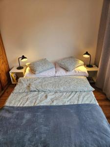 a bed in a bedroom with two lamps on two tables at Apartament Stay with Gdynia in Gdynia