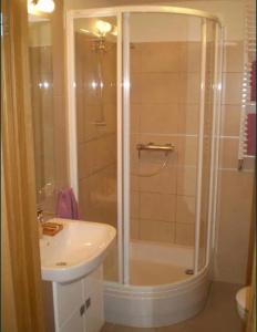 W łazience znajduje się prysznic i umywalka. w obiekcie GRECOS HOLIDAY w mieście Hel