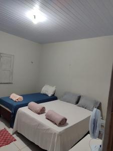 two twin beds in a room with a ceiling at Café e Cama hospedagem in Barreirinhas