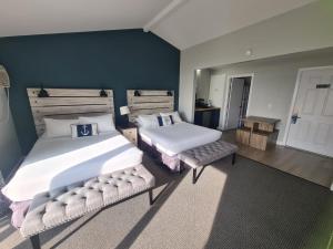 ein Schlafzimmer mit 2 Betten und einer blauen Wand in der Unterkunft Smuggler's Cove Inn in Boothbay