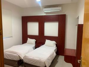 2 camas en una habitación con 2 ventanas en مراسم رفحاء للشقق المخدومة, en Rafha