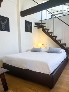 - une chambre avec un grand lit et un escalier dans l'établissement ComeCasa Ampio Bilocale in Piazza San Secondo, à Asti