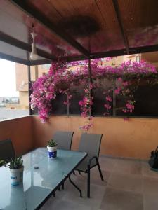 A wonderful stay at the Dead Sea في السويمة: طاولة وكراسي مع زهور وردية على الحائط