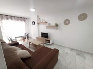 een woonkamer met een bruine bank en een tafel bij Mezquitilla in Algarrobo-Costa