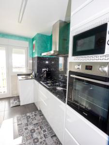 uma cozinha com armários brancos e um forno com placa de fogão em Playa el Clot - Vinaròs em Vinarós