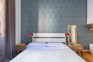 a bedroom with a white bed and a blue wall at Charming suite with view in the heart of Rome in Rome