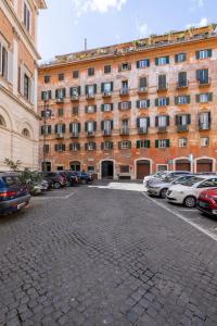 a large building with cars parked in a parking lot at Charming suite with view in the heart of Rome in Rome