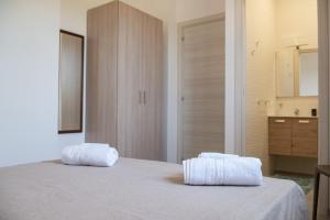 a bedroom with a bed with two towels on it at Villa Marica in Partinico