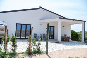 a white house with a patio and chairs at Villa Marica in Partinico