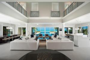 a living room with white furniture and the ocean at Sun Salutations villa in Driftwood Village