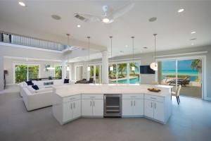 a large kitchen with white cabinets and a living room at Sun Salutations villa in Driftwood Village