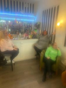 grupa ludzi siedzących w fotelach w barze w obiekcie The Cosy Nook w Blackpool