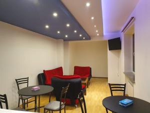 Doss Guest Hause في يريفان: غرفة انتظار وكراسي حمراء وطاولات