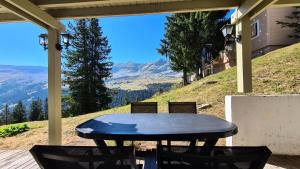 einen Tisch und Stühle auf einer Veranda mit Aussicht in der Unterkunft Chalet De L'arbaron - Studio pour 4 Personnes 92 in Flaine