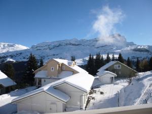 ein schneebedecktes Haus mit einem Berg im Hintergrund in der Unterkunft Chalet De L'arbaron - Studio pour 4 Personnes 92 in Flaine