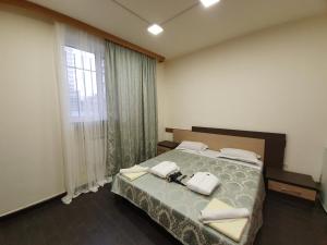 a bedroom with a bed and a large window at Doss Guest Hause in Yerevan