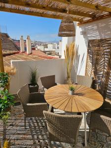 a wooden table and chairs on a patio at Apartamentos de la Huerta in Alicante