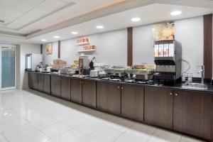 a kitchen with a long counter in a restaurant at Comfort Inn & Suites New Orleans Airport North in Kenner