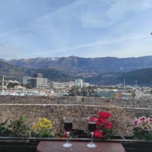 two glasses of wine sitting on a table with a city at Guesthouse Bogdanovic in Budva
