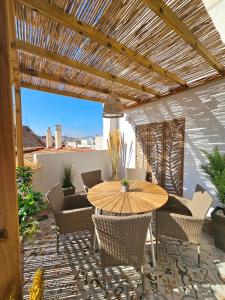 a patio with a wooden table and chairs on a patio at Apartamentos de la Huerta in Alicante