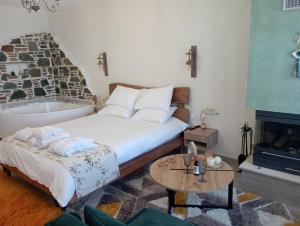 een slaapkamer met een bed, een bad en een tafel bij ΠΑΛΙΟ ΧΩΡΙΟ in Palaios Panteleimon
