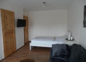 Schlafzimmer mit einem weißen Bett und einem TV in der Unterkunft Kleines Appartement Gut und Preiswert in Stuttgart