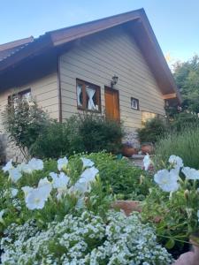 un jardín frente a una casa con flores en Tierras del sur I en Villa La Angostura