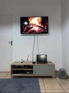 a living room with a tv on a wall at Rest Easy with 24/7 security in Cape Town