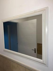 a mirror on a wall in a bathroom at Rest Easy with 24/7 security in Cape Town