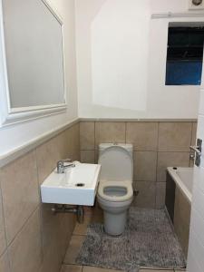 a bathroom with a toilet and a sink at Rest Easy with 24/7 security in Cape Town