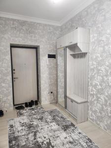 a white room with a door and a rug at Hilmar in Tashkent